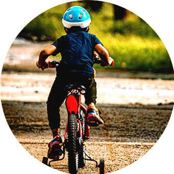 Criança andando de bike infantil com capacete