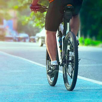Pessoa com trajes de ciclista pedalando em bicicleta em rua