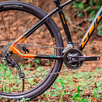 Bicicleta Aro 29 com quadro preto e detalhes laranja utilizando transmissão OGGI